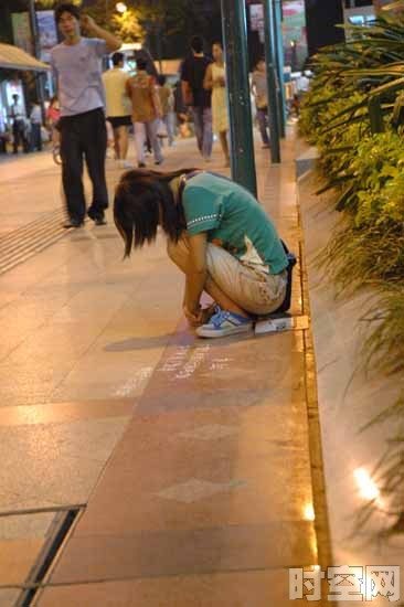 实拍街头职业“求助”女,低头等待，显得很可怜、害羞，好像这是第一次